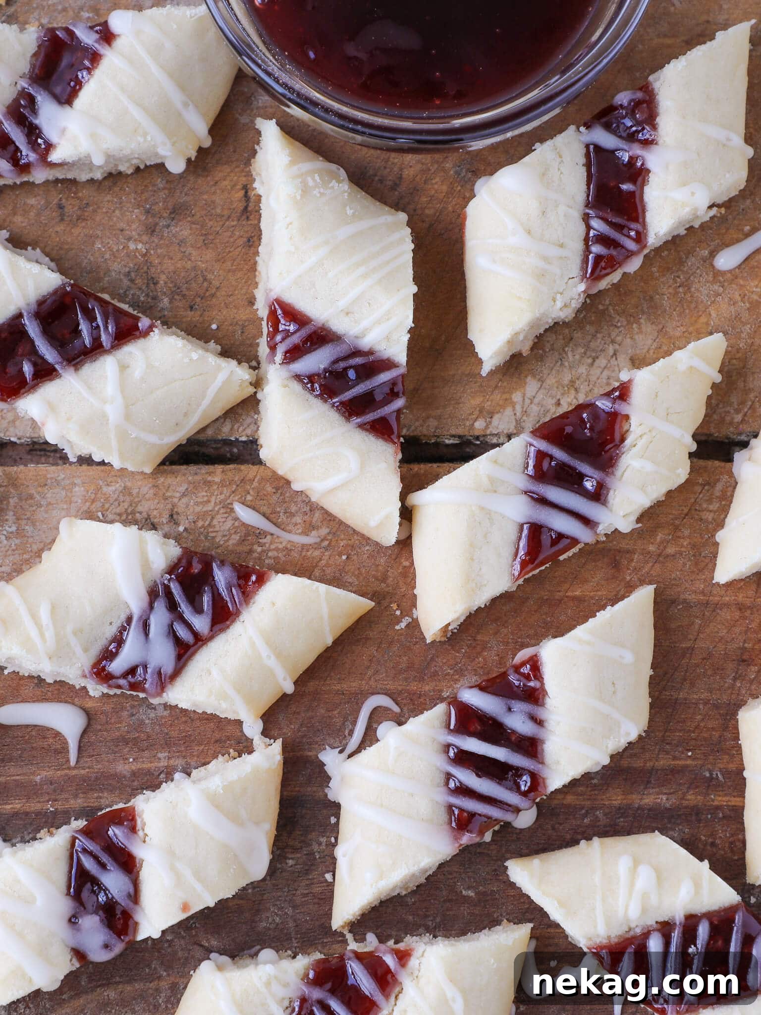Danish Raspberry Ribbon Cookies arranged on a wooden backdrop, showcasing their distinct ribbon of jam.