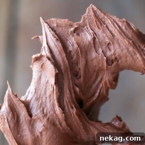 Decadent Chocolate Frosting 4 Chocolate buttercream peaks on a paddle attachment, highlighting its perfect consistency.