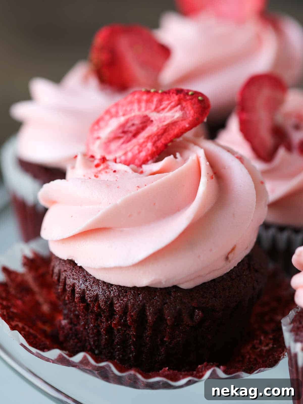 Red velvet cupcake with a peeled cupcake wrapper, showcasing its moist texture and white chocolate chips.