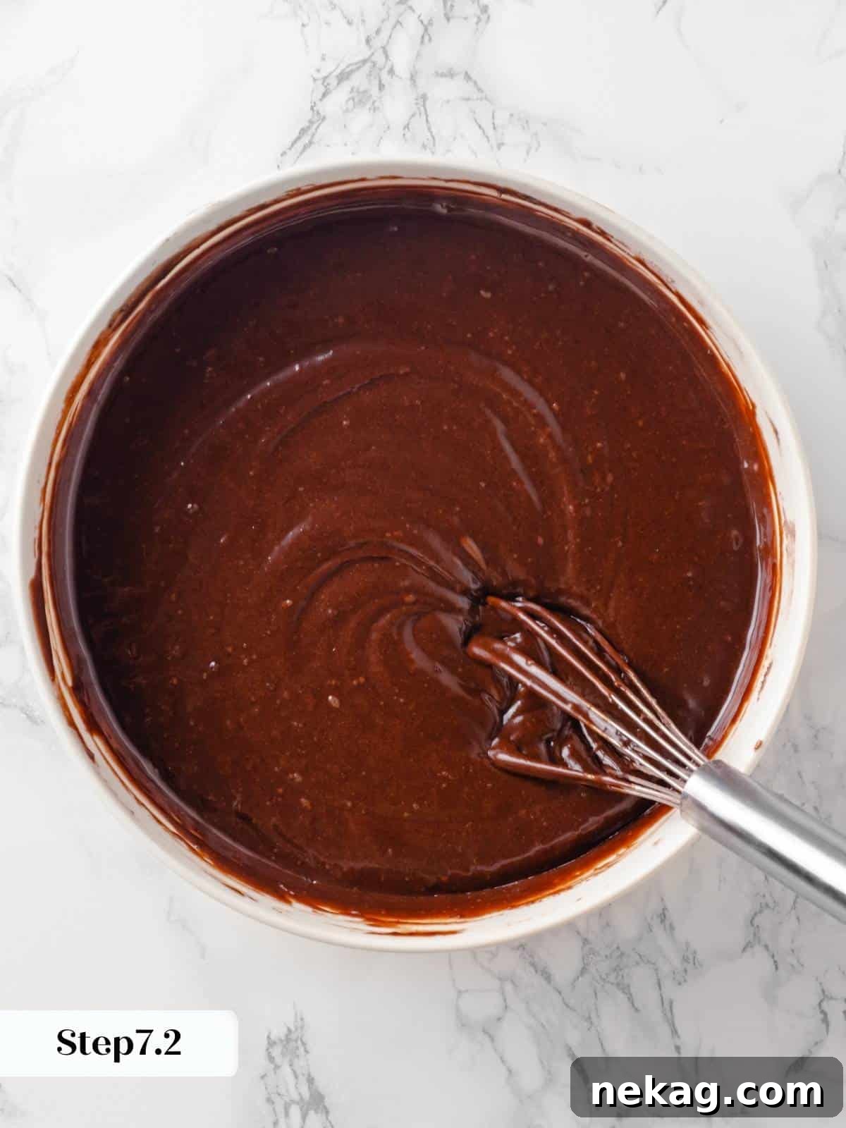 A rich, glossy chocolate cake batter, perfectly mixed and smooth, ready to be divided into pans.