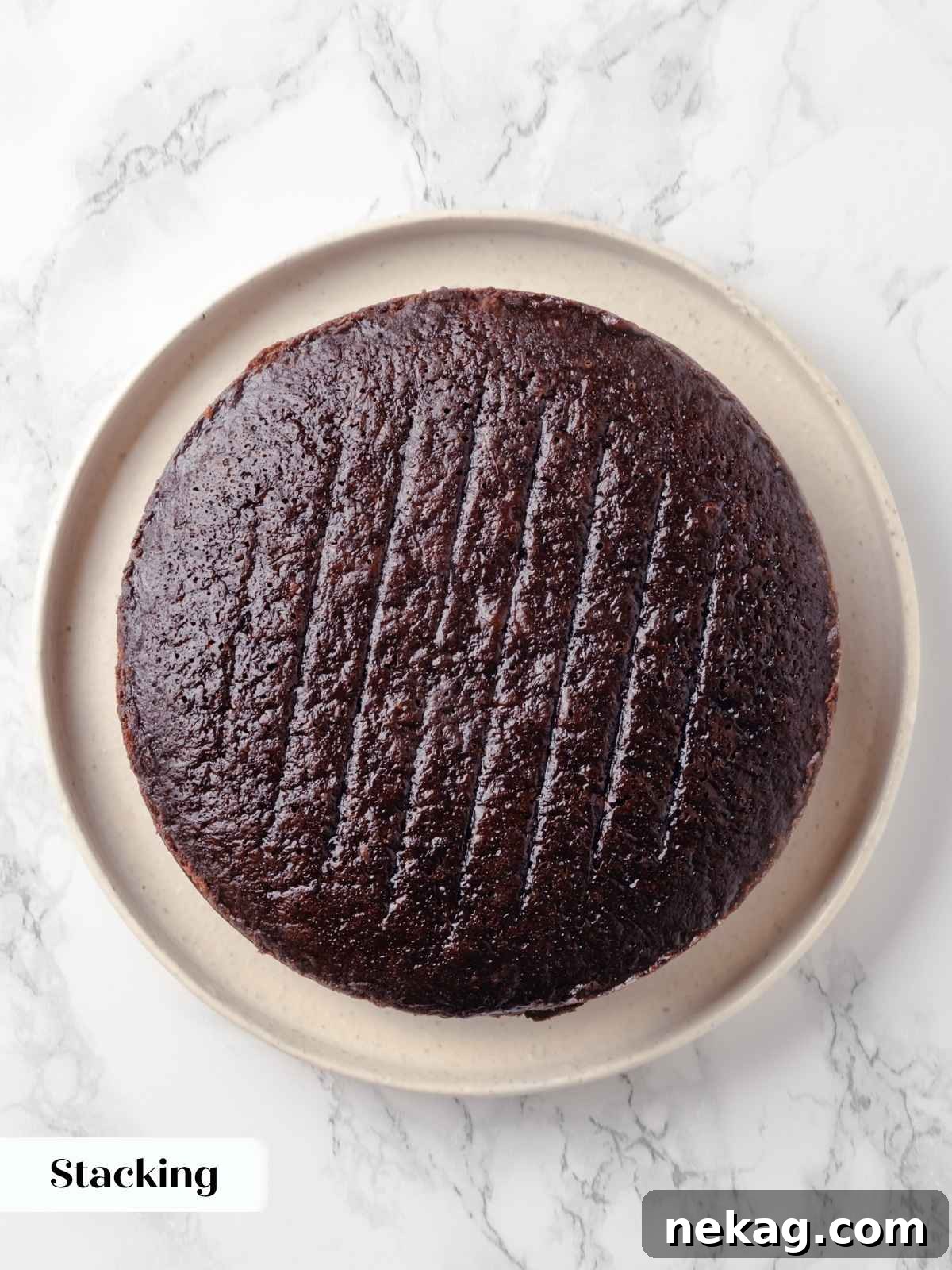 The second cake layer carefully placed on top of the frosted first layer, awaiting its own decadent covering.