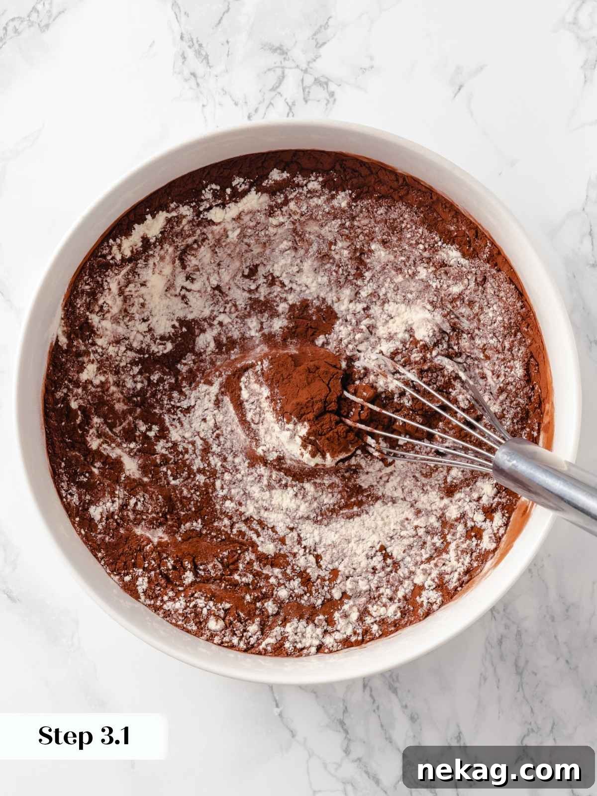 Dry cake ingredients including flour and rich cocoa powder, unmixed in a bowl, ready for combining.