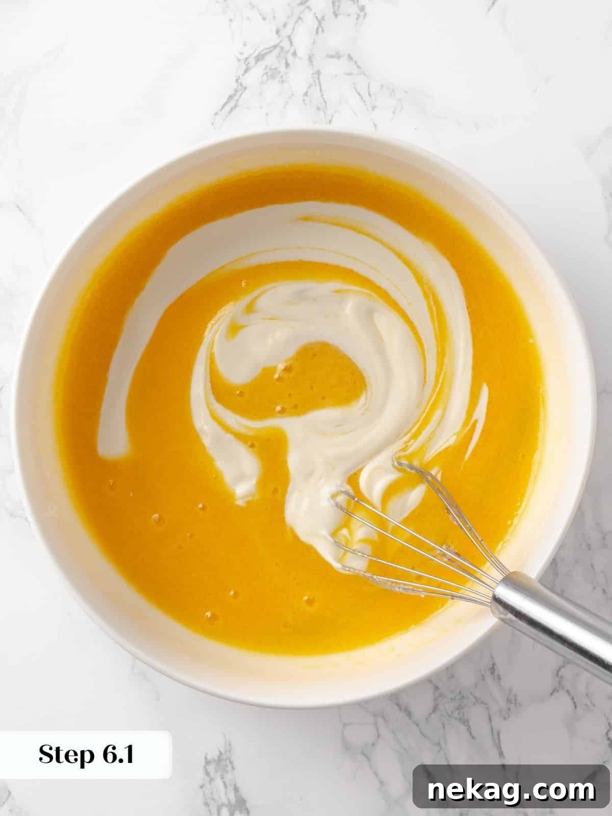 Whole milk being carefully poured into the existing wet ingredients, contributing to the cake's exceptional moisture.
