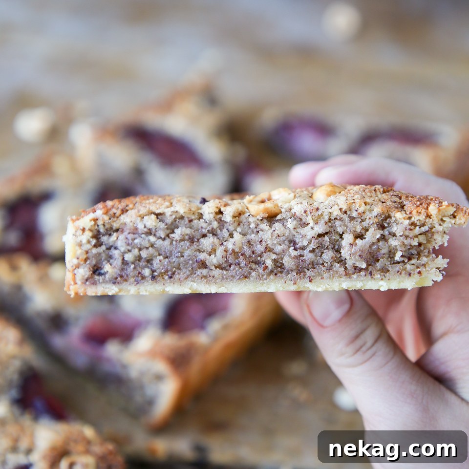 Close-up of the tart's filling, highlighting the texture of the hazelnut frangipane and the vibrant color of the poached pears.