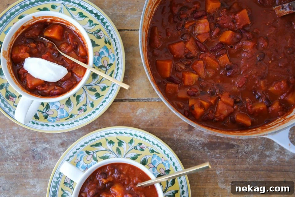 Vegan chili in two serving bowls and dutch oven.