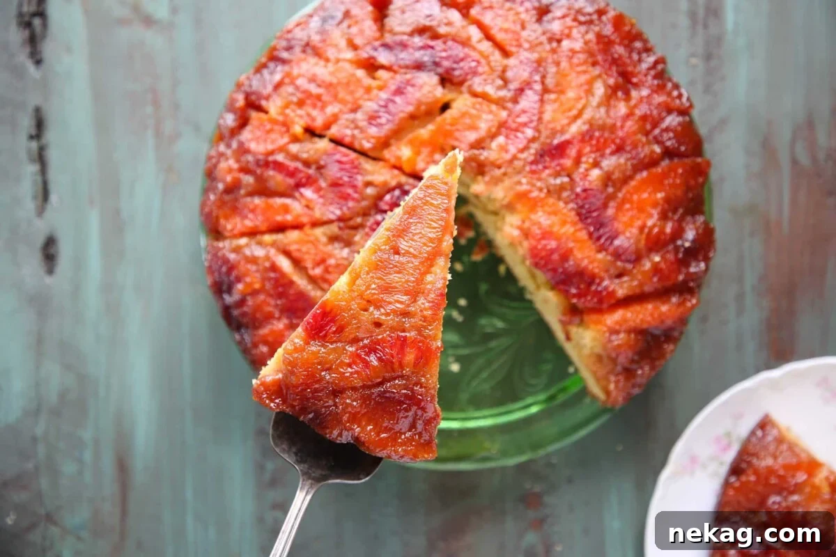 A whole Orange Upside-Down Cake on a white marble surface, beautifully presented.