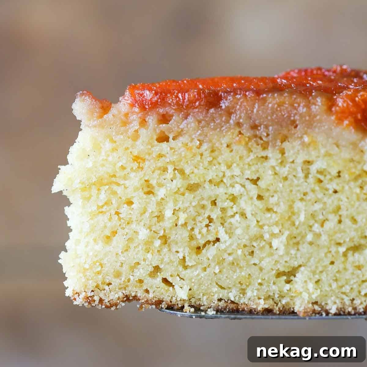 Soft cake texture viewed in a perfect slice of orange upside down cake.