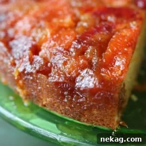 Golden brown edges of orange upside down cake on a vibrant green plate.