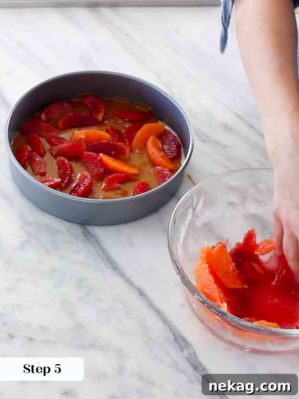 Carefully arranging vibrant orange slices in the cake pan.