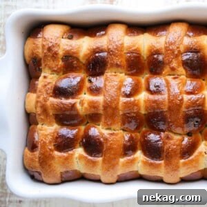 Golden Sourdough Hot Crossed Buns baked in a white baking dish.