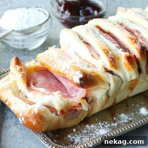 This Monte Cristo Pull Apart Bread is full of savory meats and melty cheese. It's topped with a dusting of powdered sugar and served with raspberry preserves. Works great as a breakfast, lunch, dinner, or appetizer!