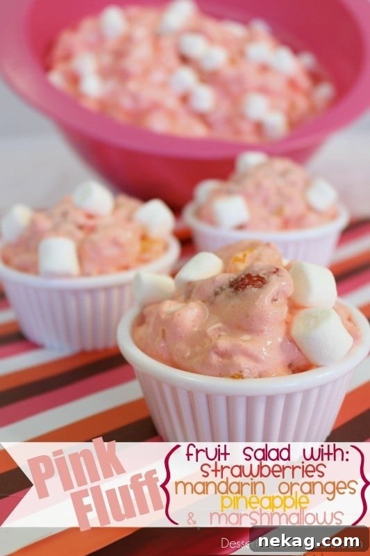 A vibrant pink fluff fruit salad, perfect for summer gatherings.
