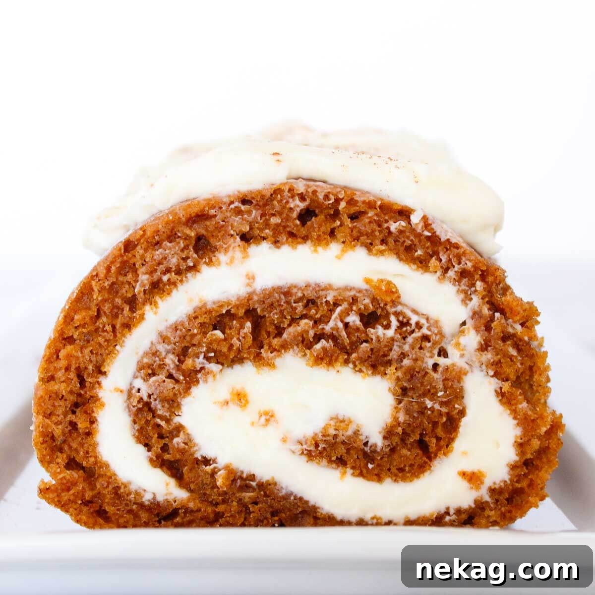 Heavenly Pumpkin Roll with Cream Cheese Filling 4 Close-up of a perfectly sliced pumpkin roll, showcasing the beautiful swirl of the moist cake and rich cream cheese filling, ready to be enjoyed.