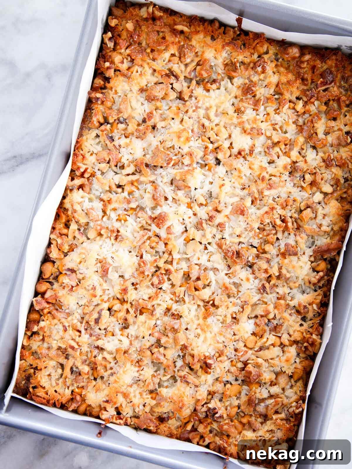 Enchanted Stacked Delights 5 unsliced pan of baked 7 layer bars.