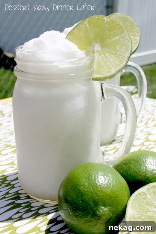 A vibrant Frozen Coconut Limeade drink in a glass, with a refreshing and creamy texture.