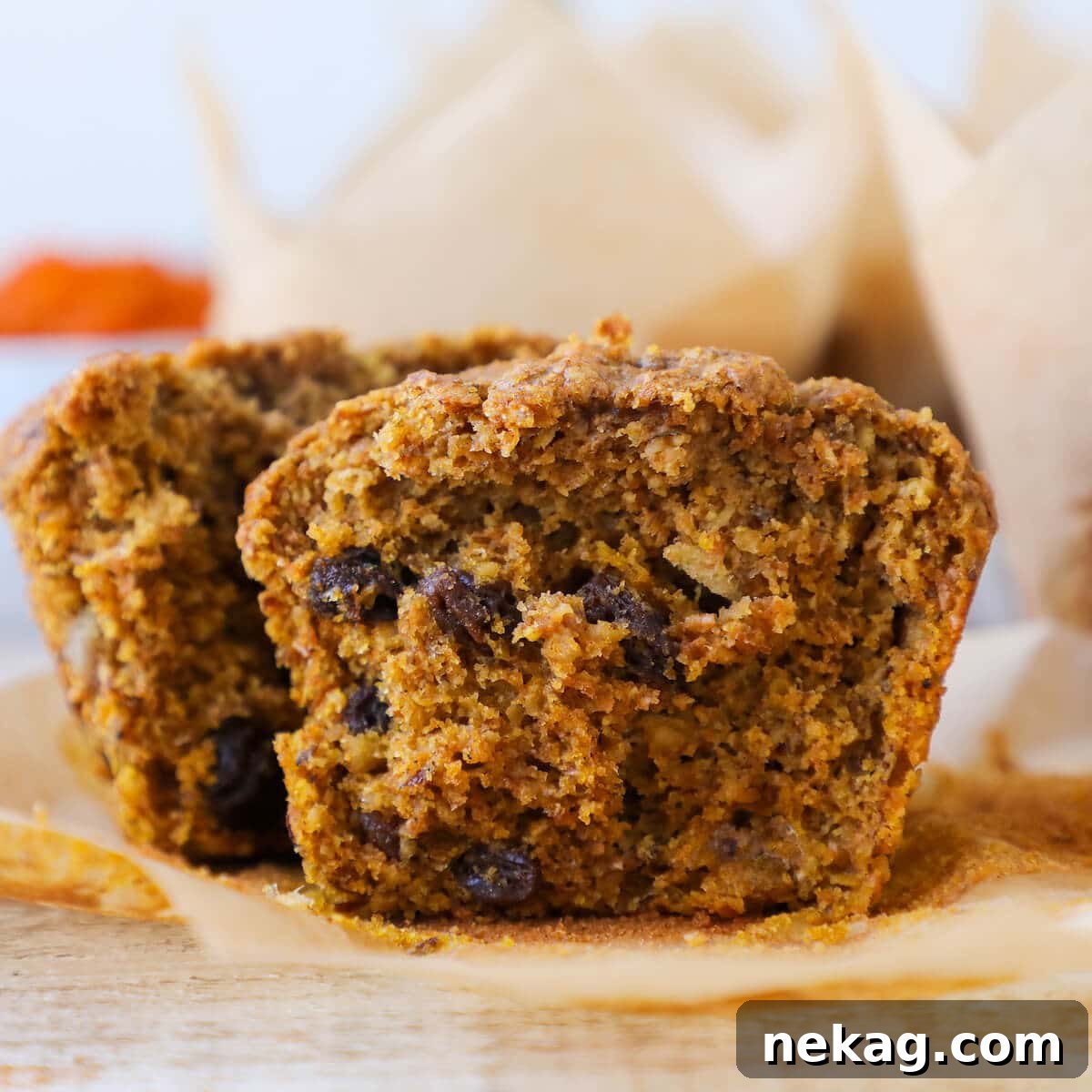 Wholesome Pumpkin Muffins 3 A healthy pumpkin spice bran muffin sliced in half, revealing its moist, tender interior texture with visible flecks of bran and spices.