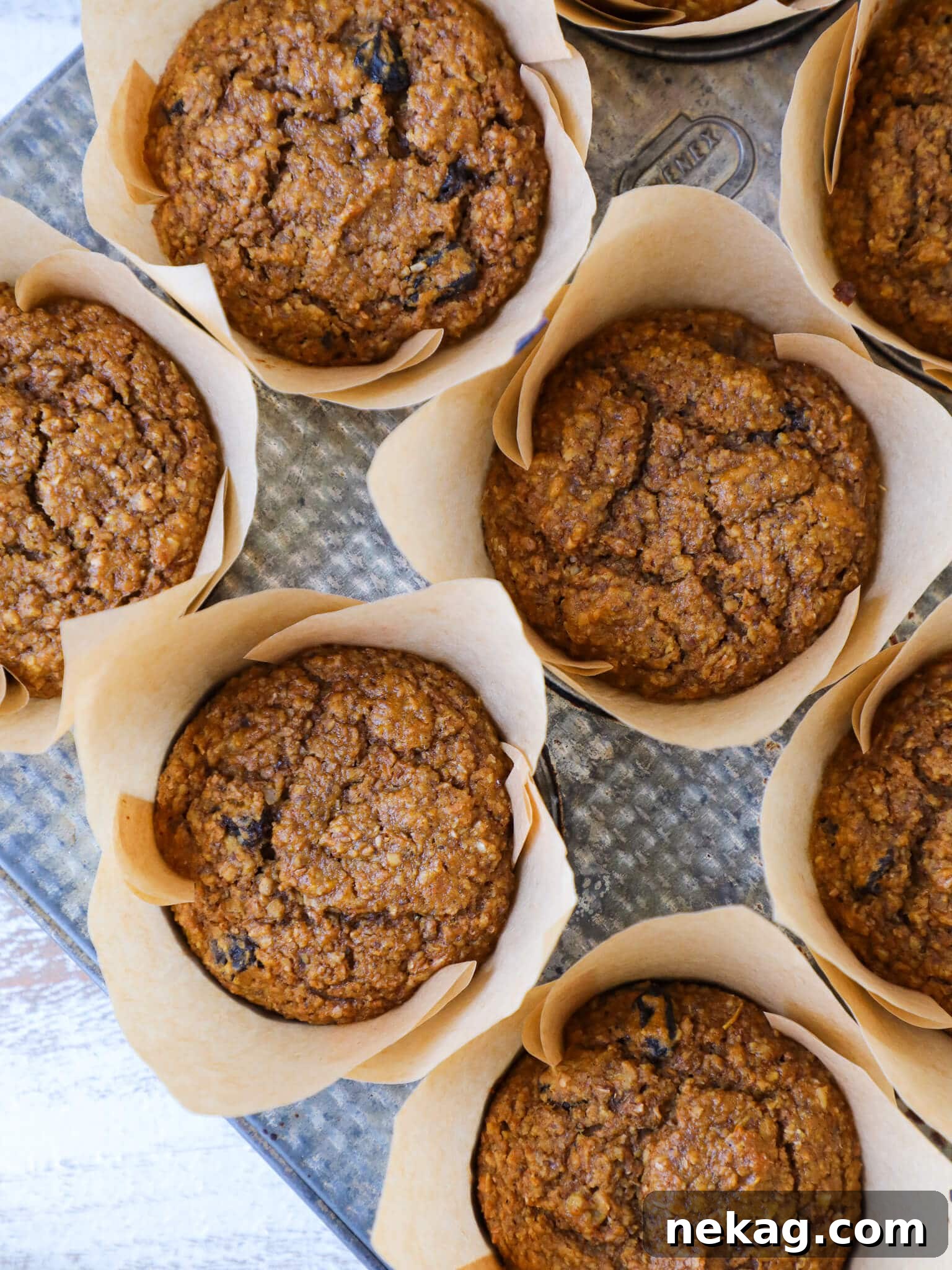 Wholesome Pumpkin Muffins 4 Freshly baked pumpkin muffins in a vintage muffin tin, ready to be enjoyed as a healthy snack or breakfast.