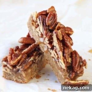 Maple Pecan Caramel Blondies leaning on parchment