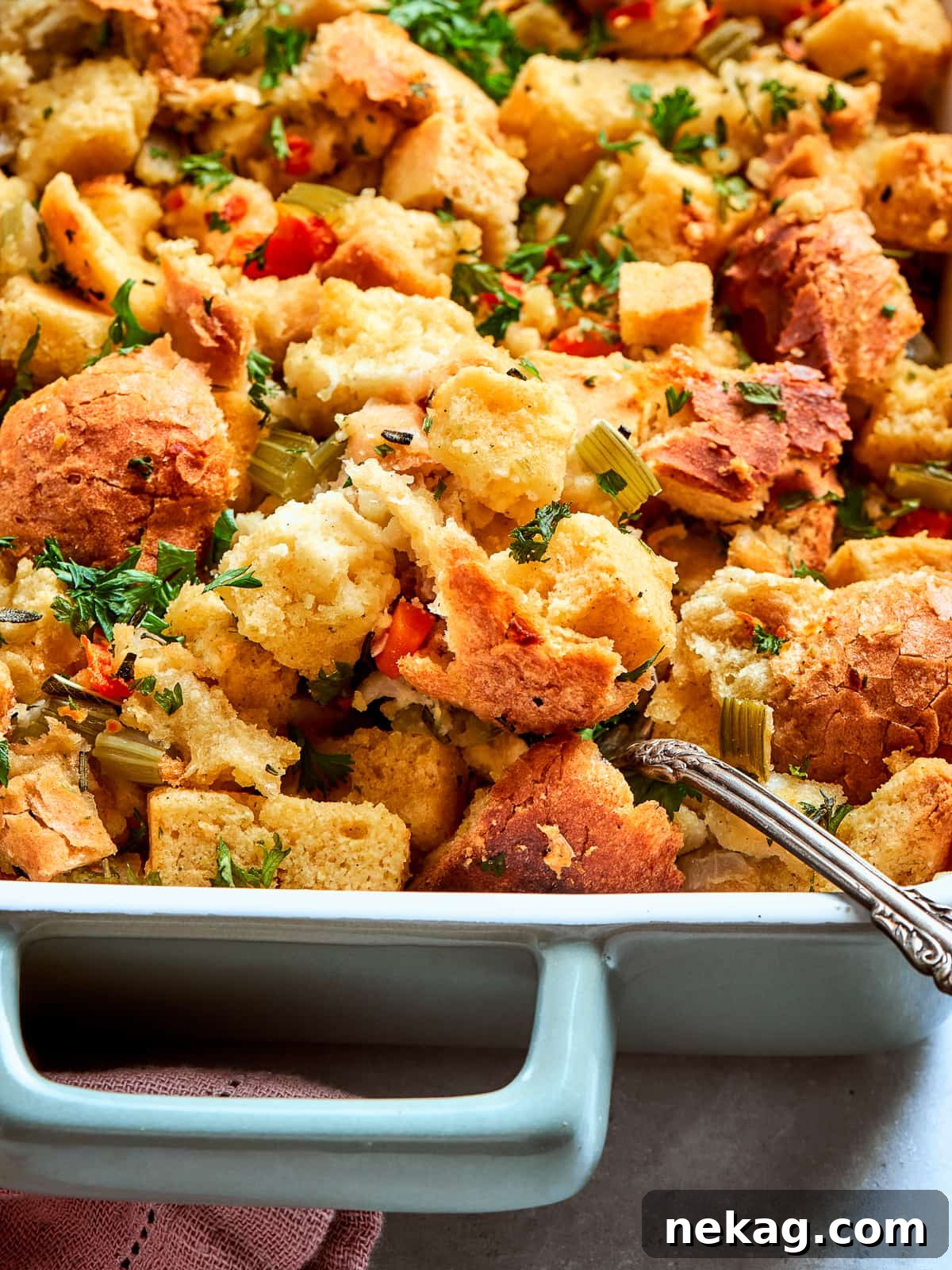 Garnished cornbread dressing topped with chopped herbs ready to serve for Thanksgiving dinner. A rustic, comforting scene of a holiday meal.