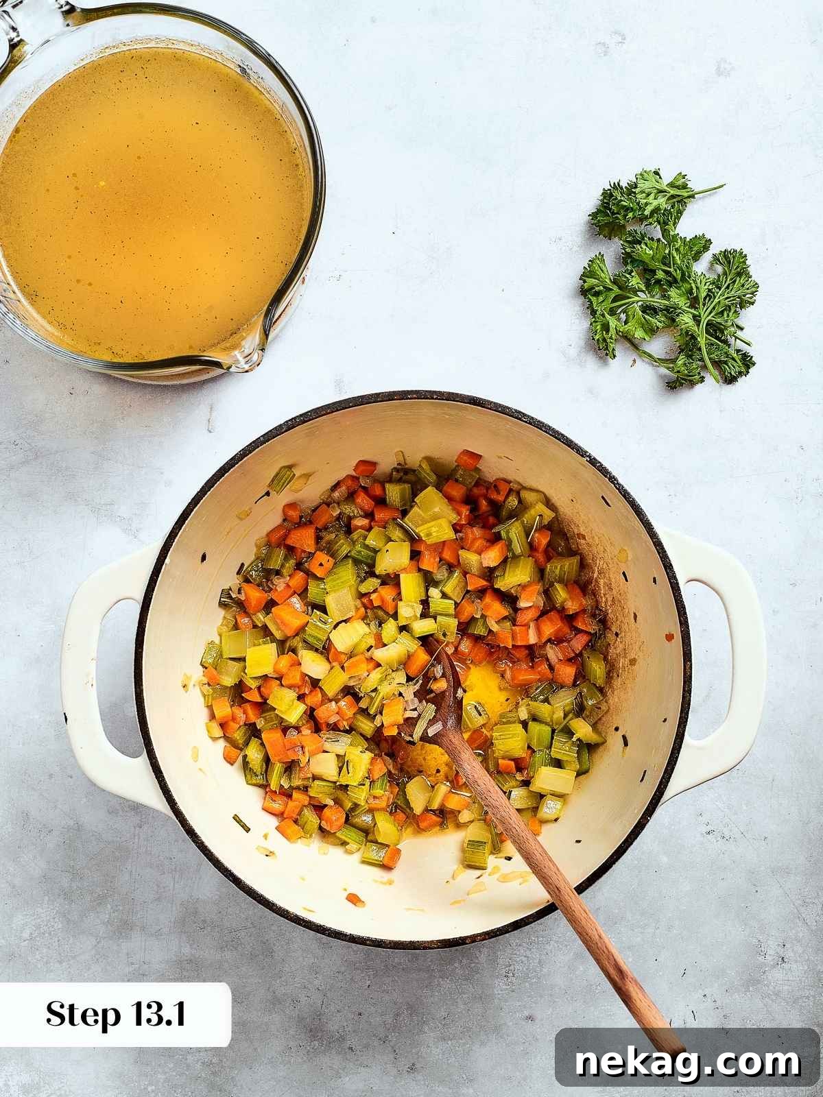 Skillet filled with finely diced sautéed onions, celery, and herbs, cooking gently to release their full aromatic flavors.