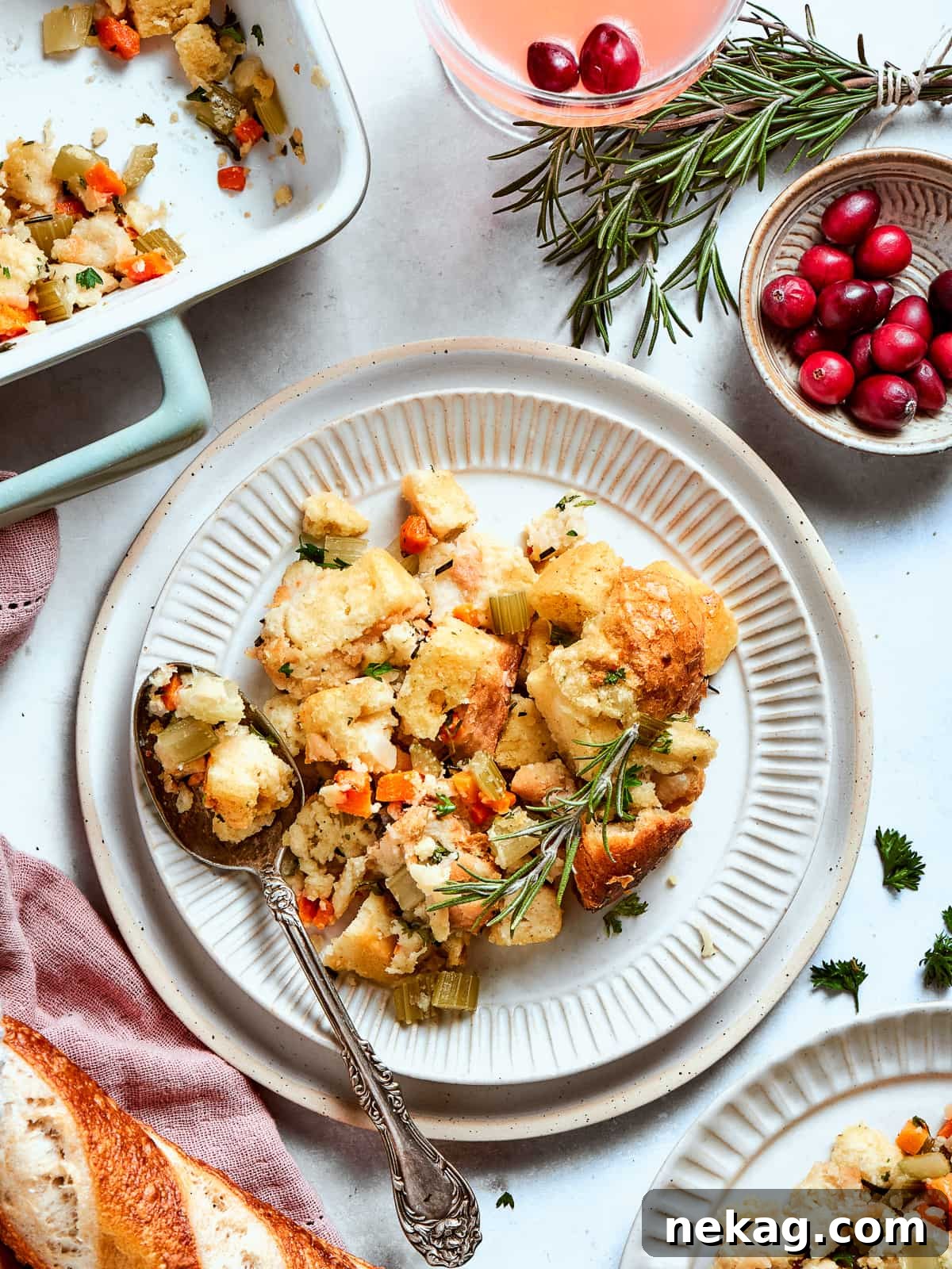 A generous portion of Southern cornbread dressing on a white plate, showcasing its tender, custardy interior and crispy, golden top.