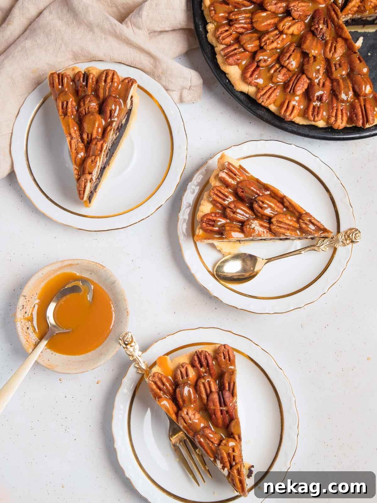 Decadent Chocolate Pecan Pie 2 Three perfectly cut slices of salted caramel chocolate pecan pie, glistening with caramel and adorned with whole pecans, presented on a white background.