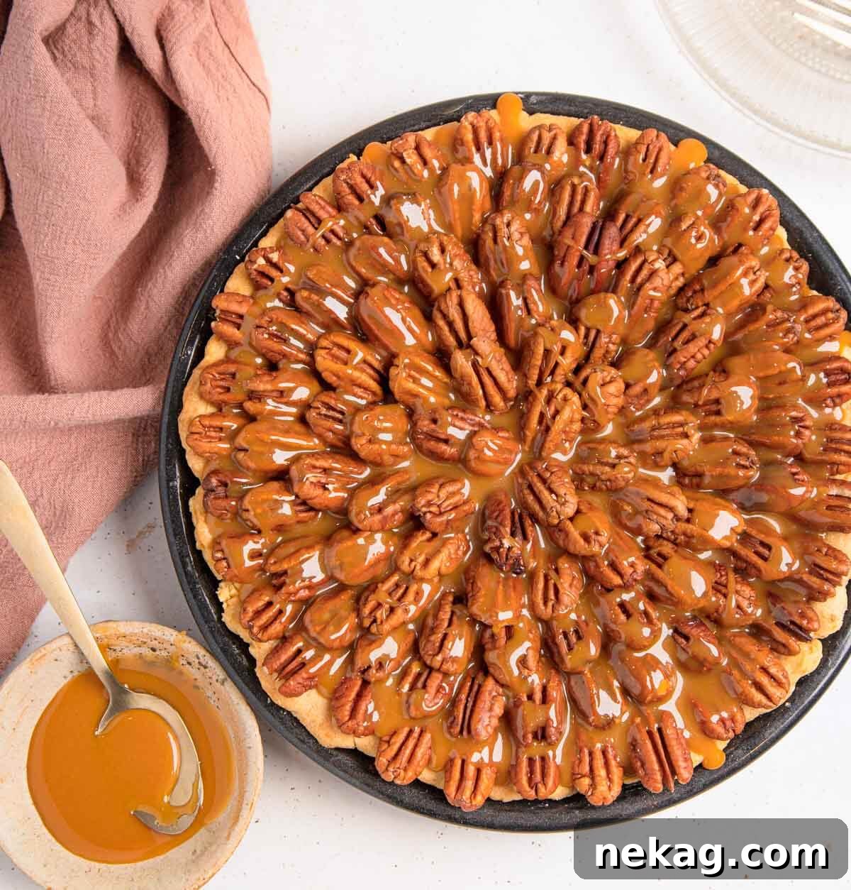Decadent Chocolate Pecan Pie 3 A whole, beautifully baked chocolate pecan pie, generously drizzled with homemade salted caramel sauce and topped with artfully arranged pecan halves.
