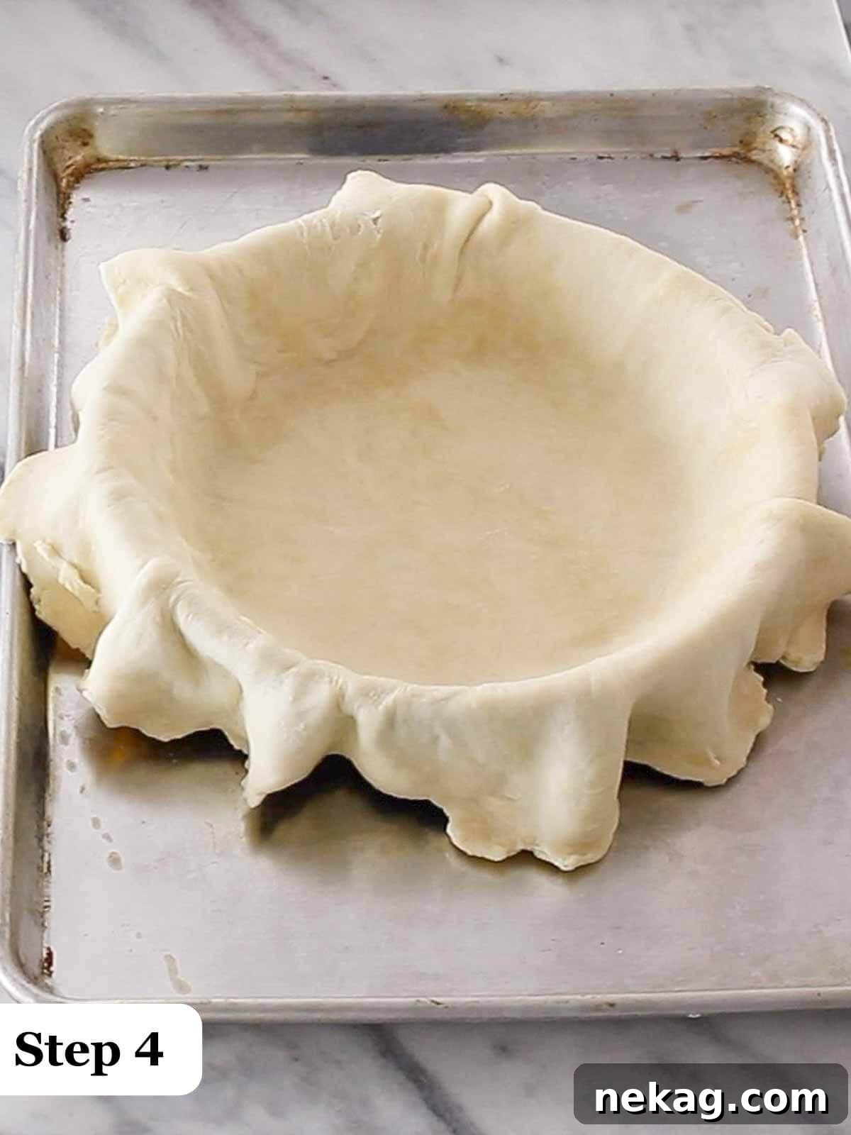 Decadent Chocolate Pecan Pie 5 Step-by-step image illustrating the careful process of draping a pie crust into a pie dish, ensuring it settles evenly without stretching.