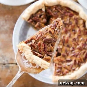 A slice of pecan pie being served, highlighting the exquisite texture and presentation.