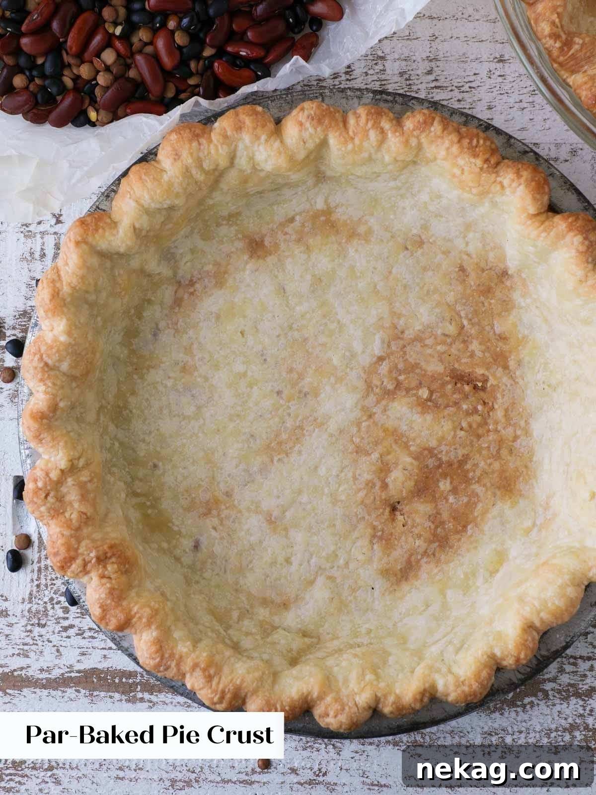 Decadent Pecan Pie Perfection 8 A partially blind-baked pie crust in a metal tin, showing its golden color and set shape.