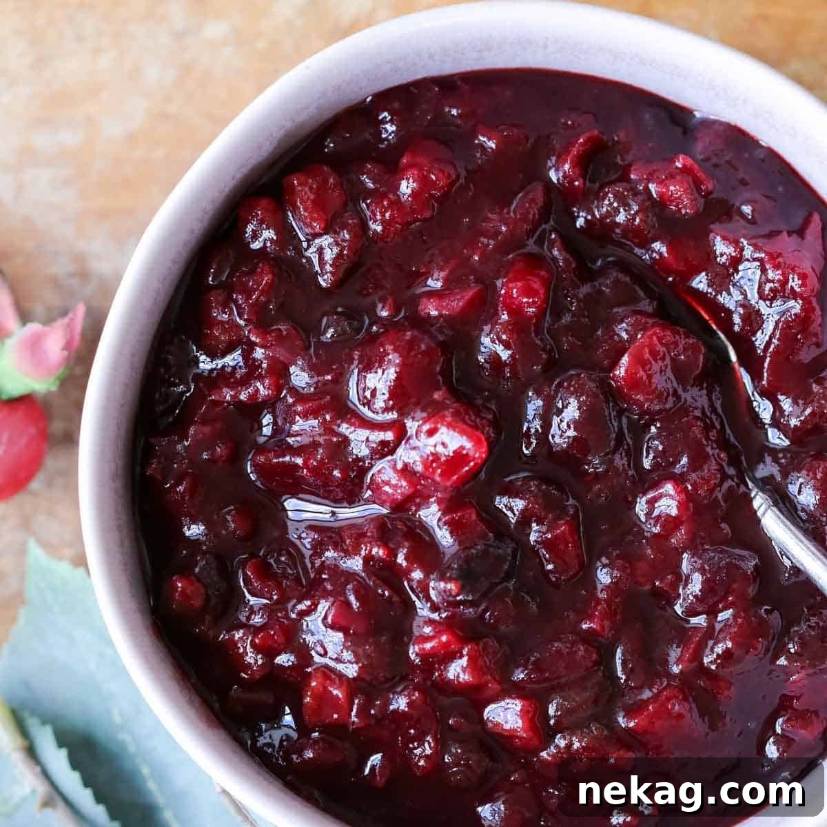 Festive Cranberry Relish 3 A bowl of freshly cooked cranberry chutney, rich in color and texture, resting on a wooden surface.