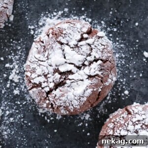 Chocolate Crackle Cookie with powdered sugar on black surface Easy Chocolate Desserts.