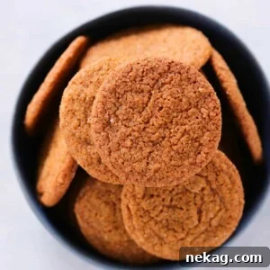 Old Fashioned Gingersnaps in a black bowl, highlighting their deep color and inviting texture.