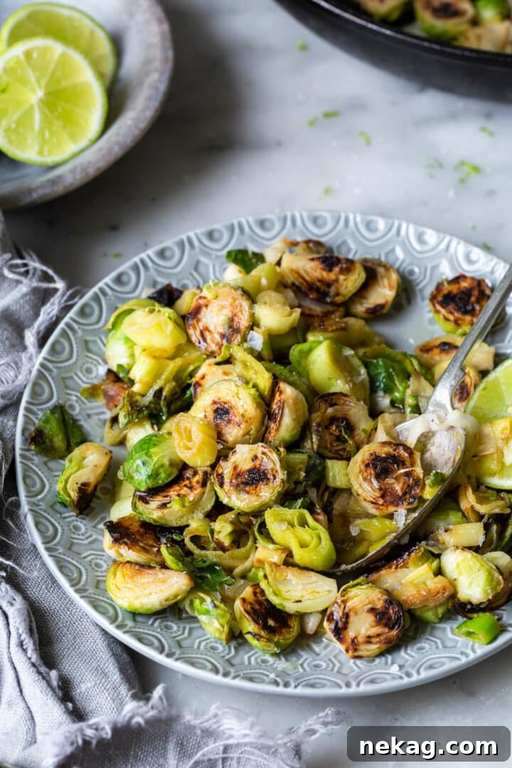 Zesty Lime-Ginger Buttered Brussels Sprouts and Leeks 4 Plated Roasted Brussels Sprouts and Leeks with Lime-Ginger Butter on a Grey Plate