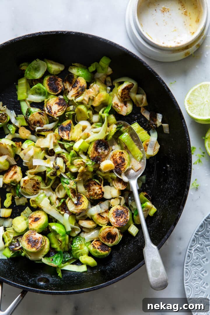 Zesty Lime-Ginger Buttered Brussels Sprouts and Leeks 5 Brussels Sprouts and Leeks with Lime-Ginger Butter in Skillet with a Serving Spoon