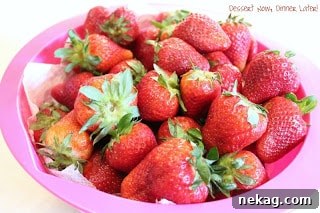 Clean, dry strawberries stored in a paper towel-lined bowl in the refrigerator
