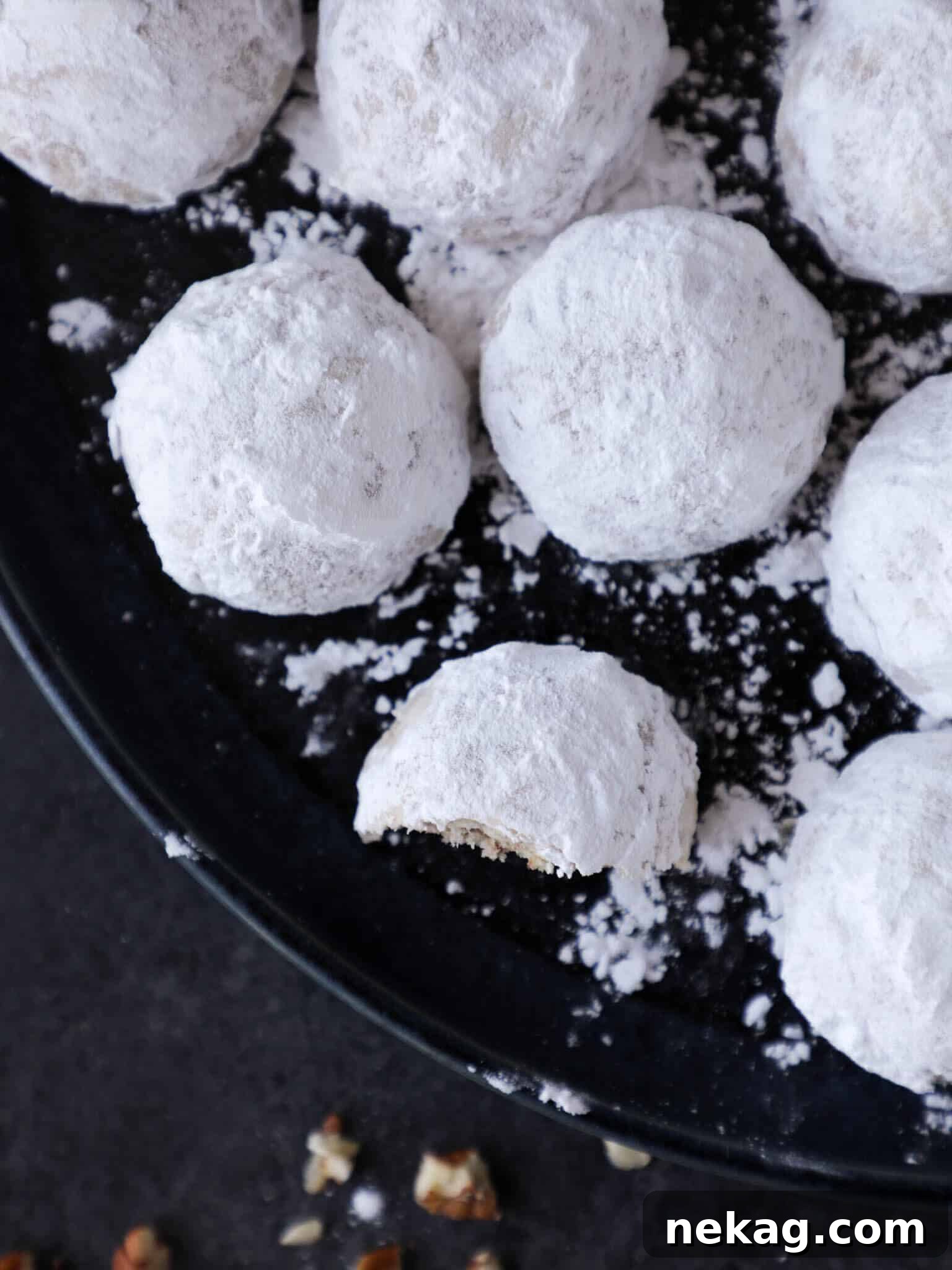 Buttery Pecan Snowball Bites 4 A close-up of beautifully finished snowball cookies, generously covered in powdered sugar, highlighting their festive appearance.