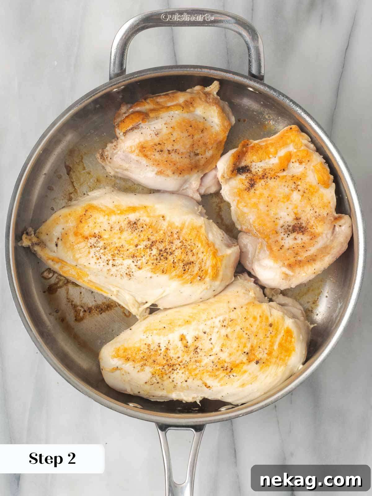 Chicken searing in a hot skillet, developing a golden-brown crust.