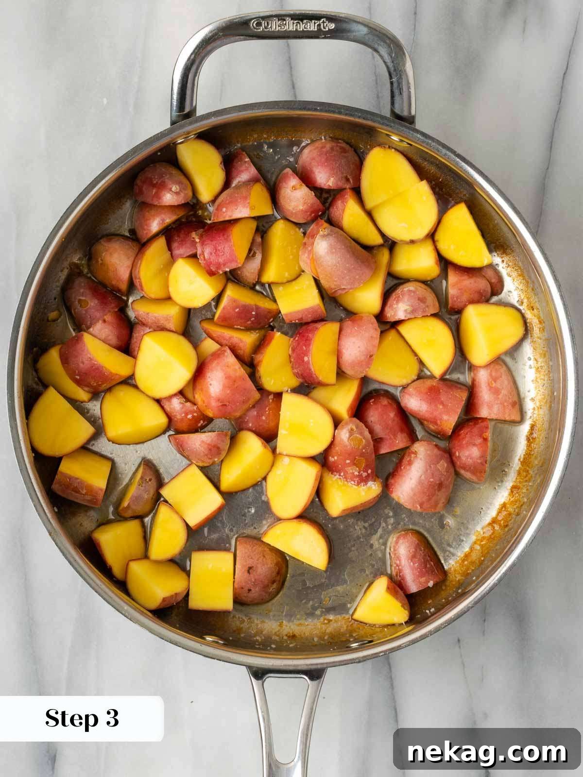 Potatoes browning in a skillet with seasoning.
