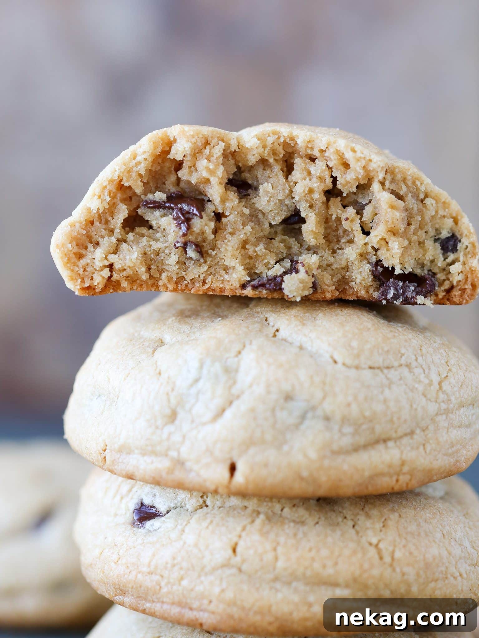 Nutty Chocolate Chip Indulgence 2 A stack of three thick, golden-brown peanut butter chocolate chip cookies with visible chocolate chips.