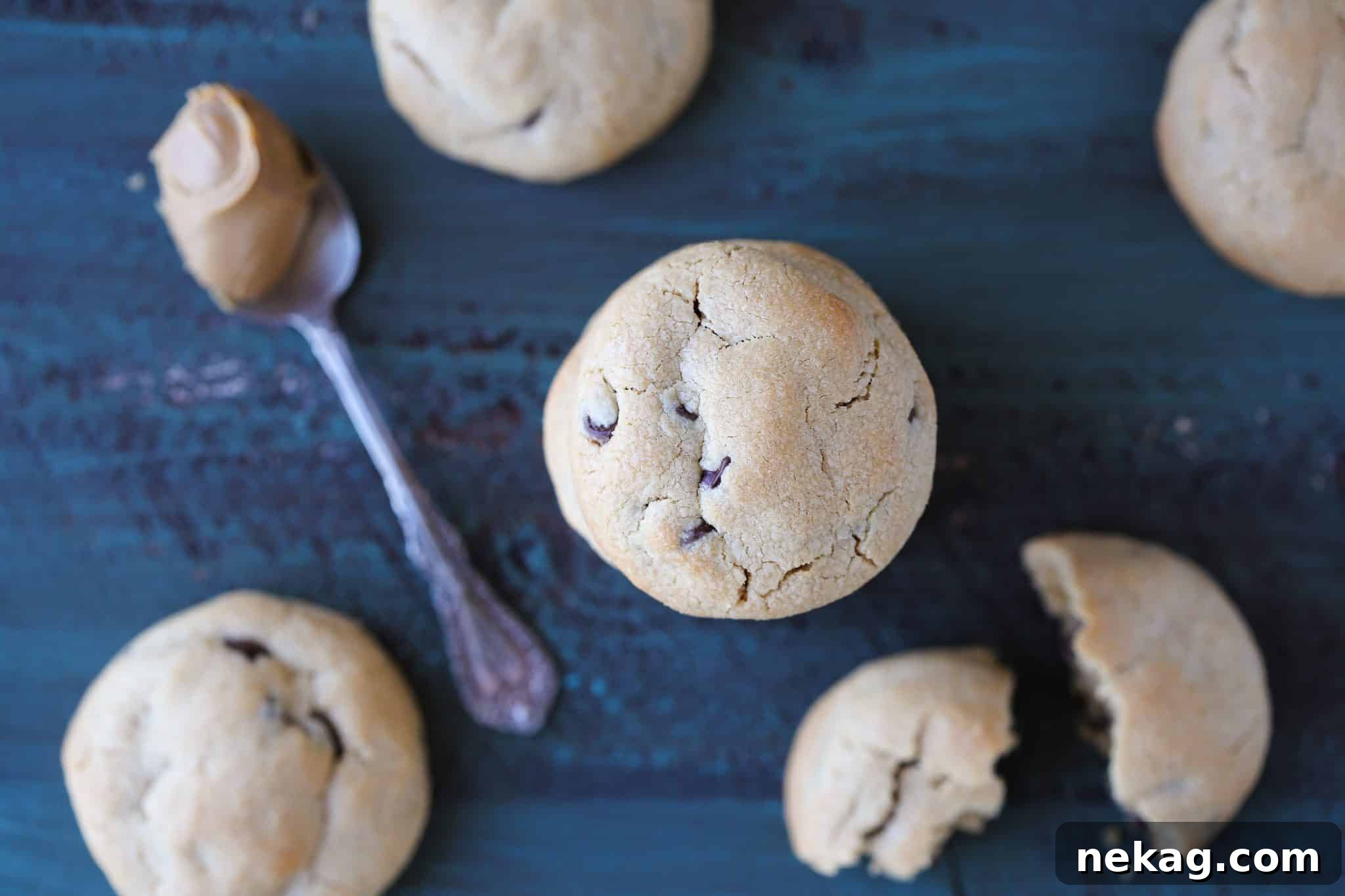 Nutty Chocolate Chip Indulgence 3 A cluster of golden-brown peanut butter chocolate chip cookies on a vibrant blue background, showcasing their thick texture.