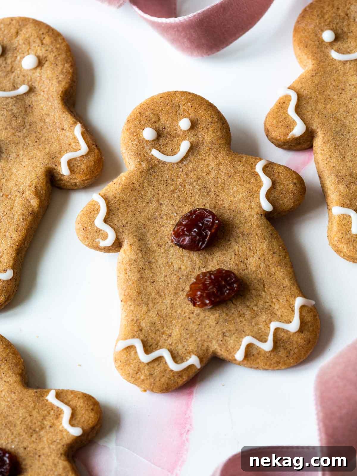 A beautifully decorated gingerbread cookie featuring elegant white icing swirls and charming raisin details, embodying festive delight.