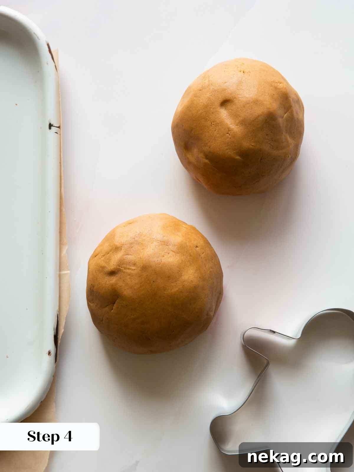 Two mounds of freshly prepared gingerbread dough resting on a clean kitchen countertop, ready for the crucial chilling process.