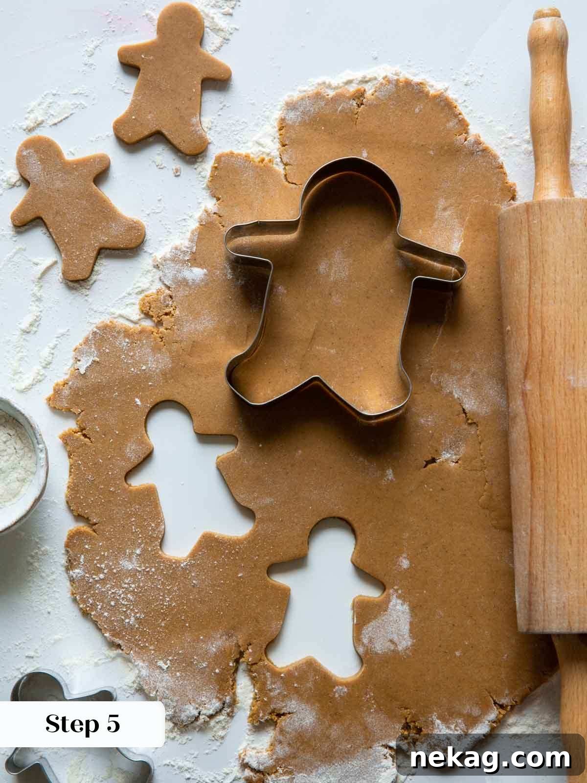 Gingerbread dough being meticulously rolled out with a rolling pin and cut into various festive shapes using holiday cookie cutters.
