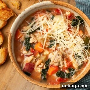 Hearty Ground Turkey Soup 9 grated cheese on top of turkey soup in bowl.