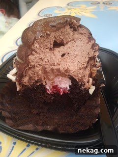 My Disney Magic Revealed 6 Chocolate raspberry cupcake with a bite taken out, revealing its creamy raspberry filling