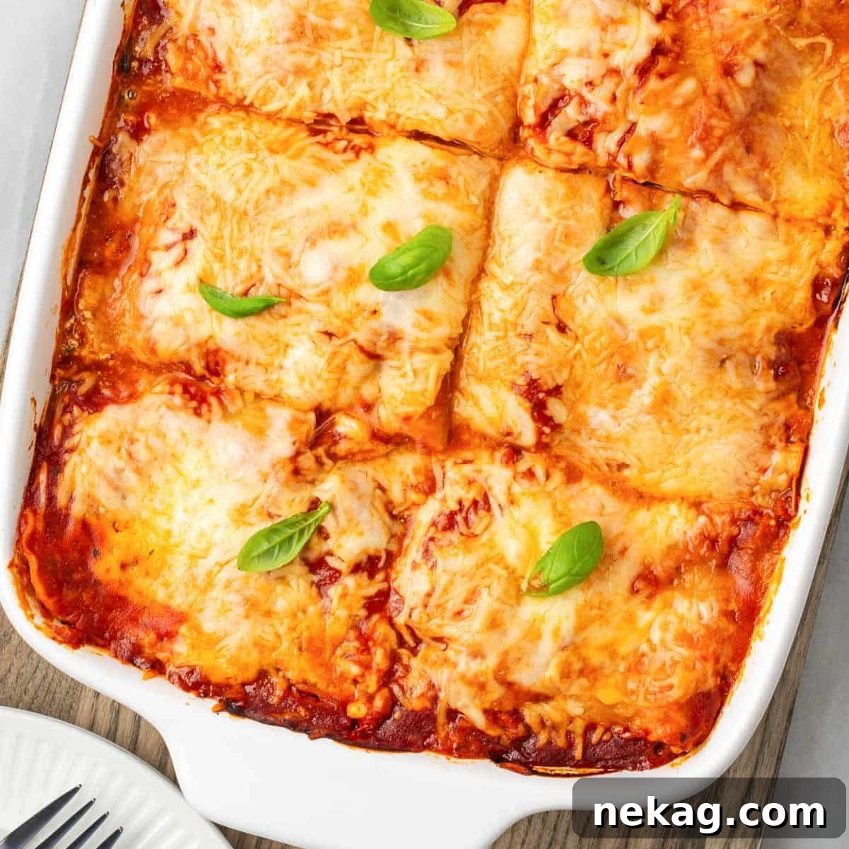Seasonal Vegetable Lasagna 3 A close-up view of a baked vegetable lasagna, showcasing its golden-brown cheesy top and bubbling sauce, ready to be served.