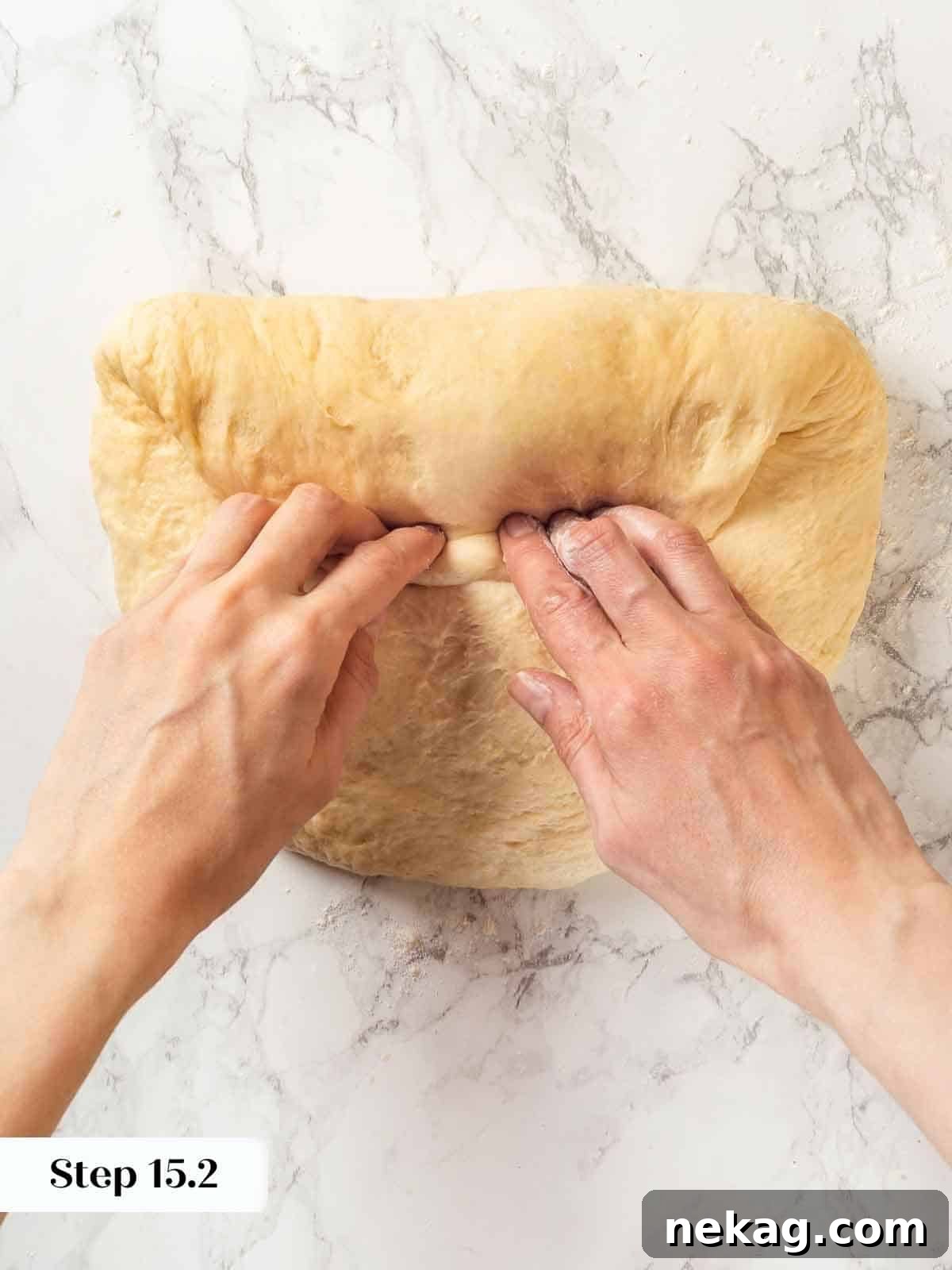 Tender Potato Loaf 16 A baker carefully folding potato bread dough into a compact shape for shaping.