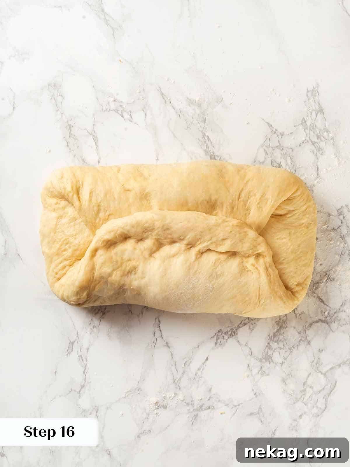 Tender Potato Loaf 18 A baker demonstrating repeated folds in potato bread dough for strength.