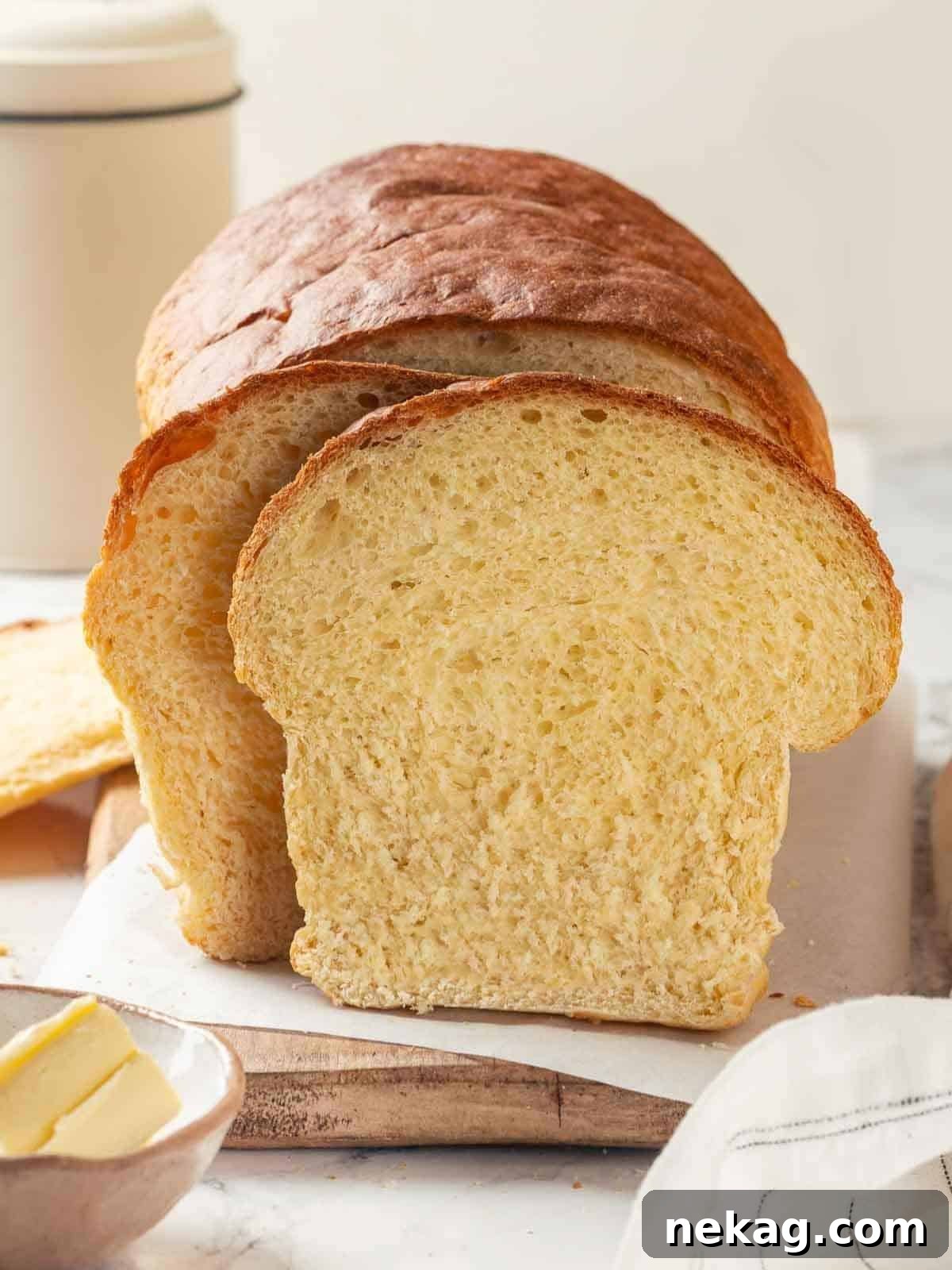 Tender Potato Loaf 22 A loaf of potato bread partially sliced, showing its soft interior and golden crust.